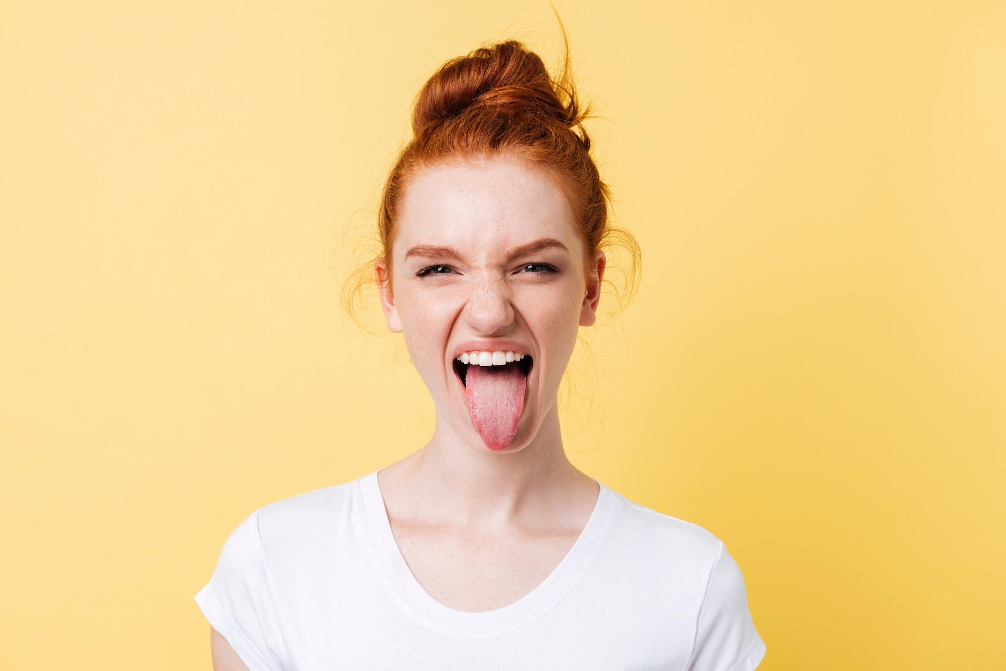 Une jeune femme tire la langue